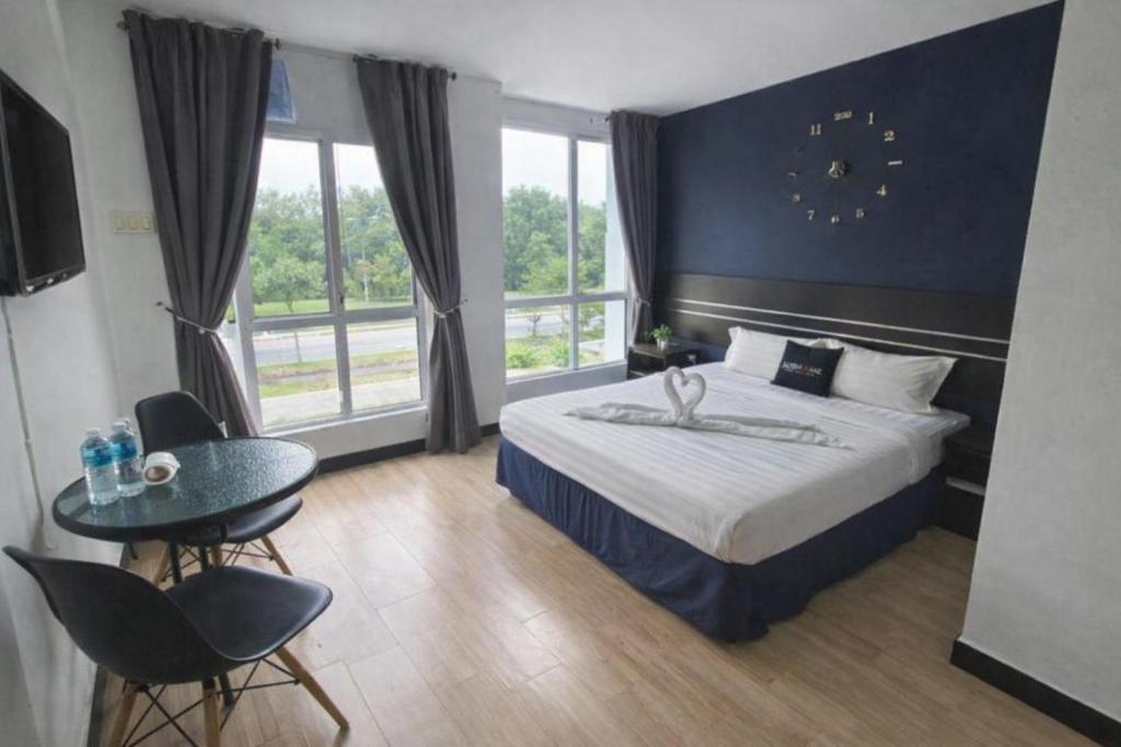 a hotel room with a bed and a table and chairs at Get Inn Hotel at 1 Capital Holdings in Gua Sai