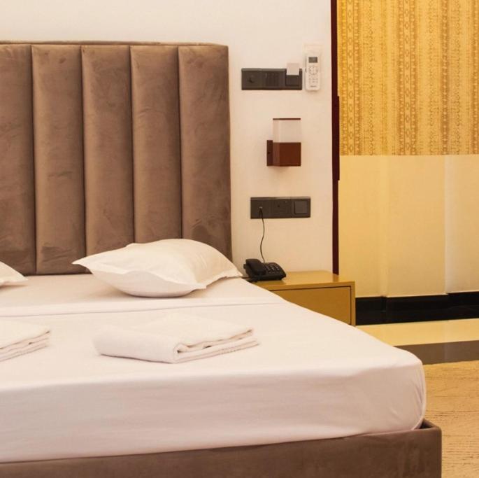 a bedroom with two beds with white sheets at Kings hotel in Colombo