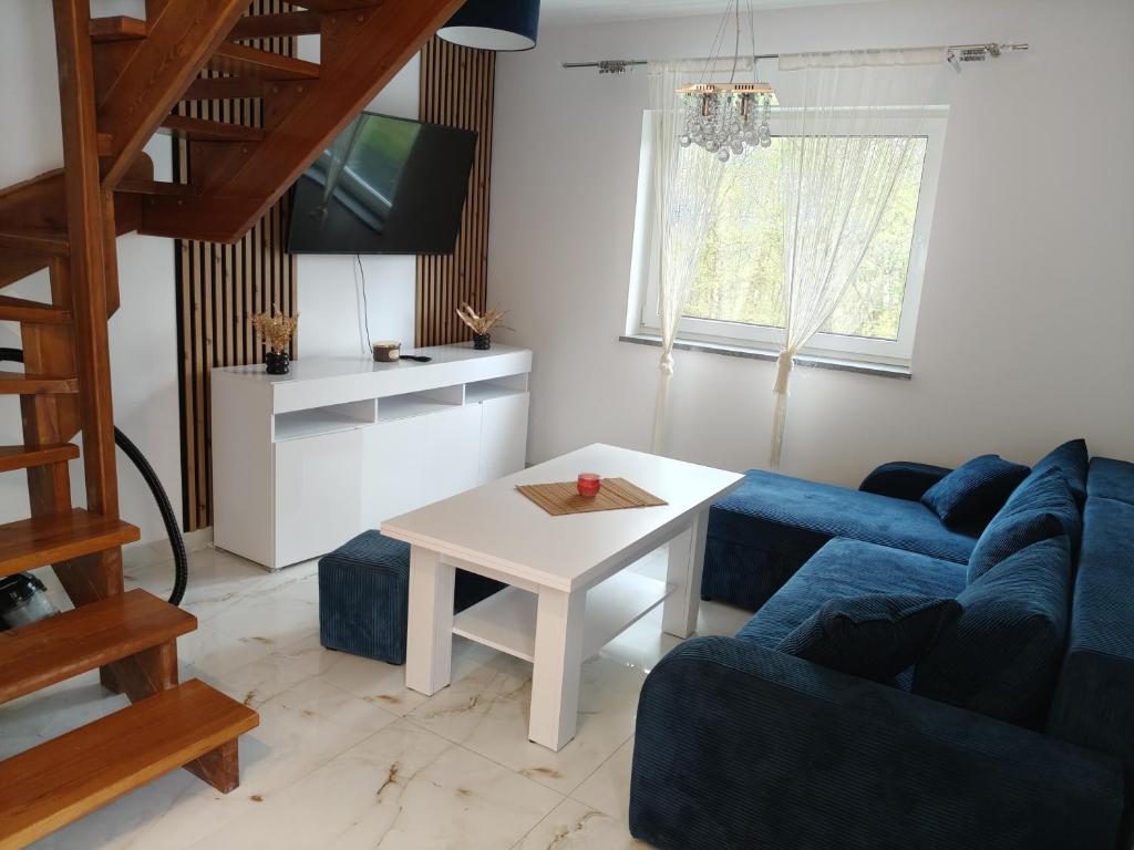 a living room with a blue couch and a table at Apartament Skorochów Jezioro in Skorochow