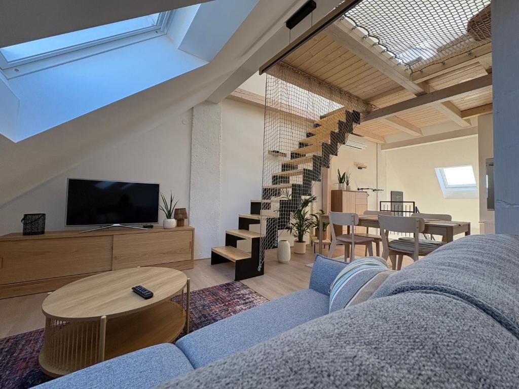 a living room with a blue couch and a tv at Apartmán Ve Štítu in Lomnice nad Popelkou