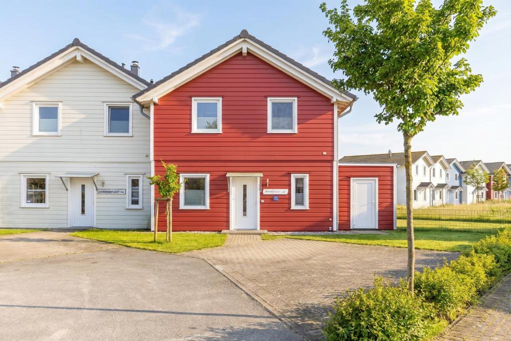 a red house and a white house at Ferienhaus Nordspitze in Dagebüll