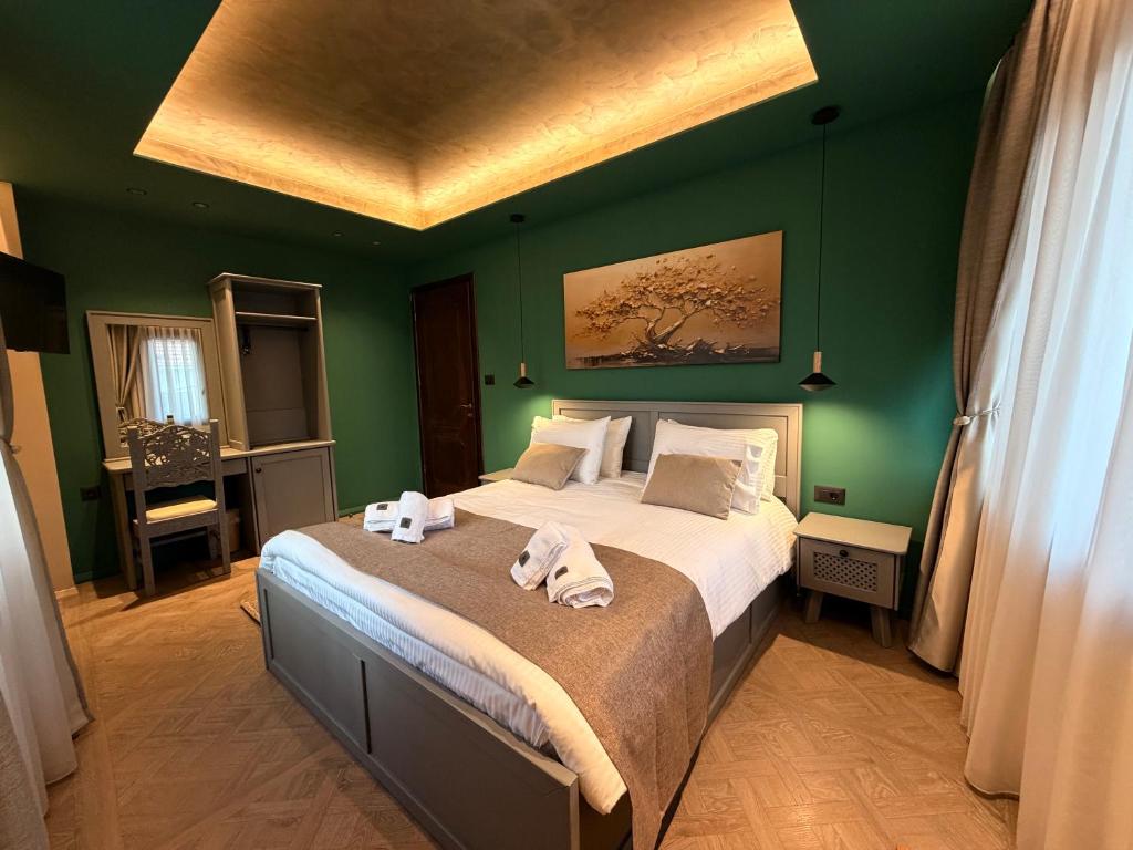 a bedroom with a large bed with green walls at DG kores in Metsovo