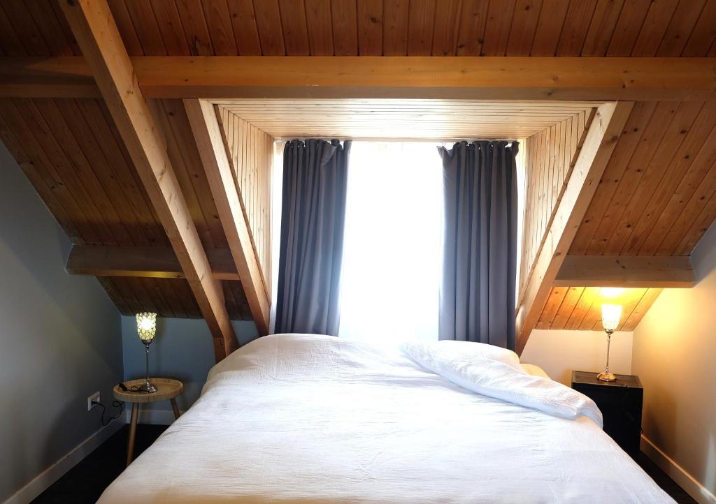 a bedroom with a large bed and a window at Zuidzuidwest in Zierikzee