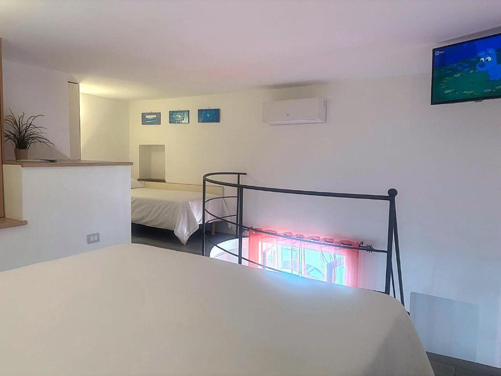 a room with two beds and a flat screen tv at Casa Mafalda B&B in Lipari