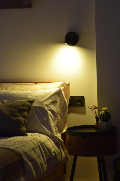 a bedroom with a bed and a table with a lamp at OE concept in Guernica y Luno