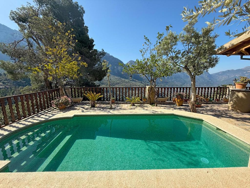 a swimming pool in a backyard with mountains in the background at Sa Màniga in Fornalutx