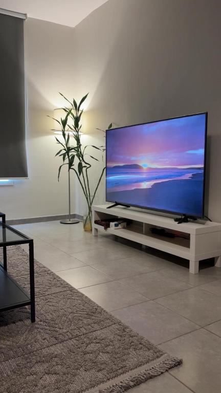 a living room with a flat screen tv on a stand at Lana's Studio in King Abdullah Economic City