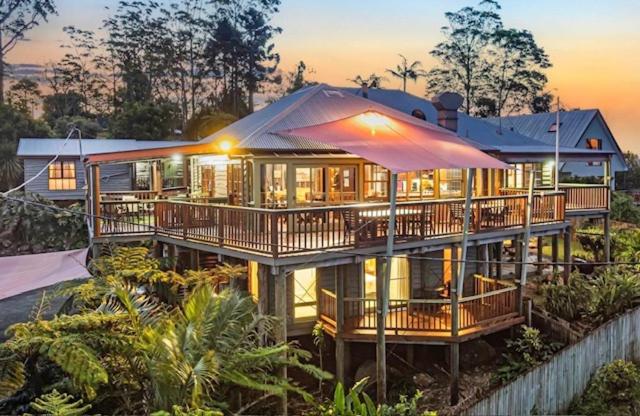 a large house with an umbrella in front of it at Tamborine Mountain Bed and Breakfast in Mount Tamborine