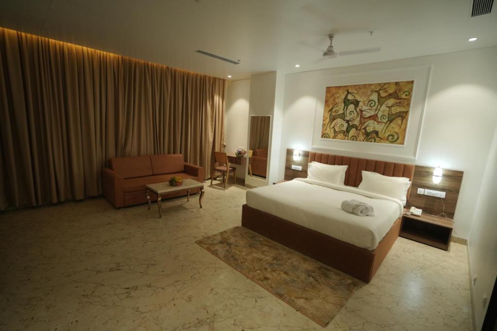 a hotel room with a bed and a couch at The Grand Icon in Chandrapur
