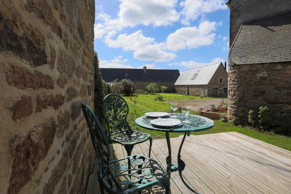 a table and chairs sitting on a wooden deck at Gite des Hauts Grève - Penty in Saint-Michel-en-Grève