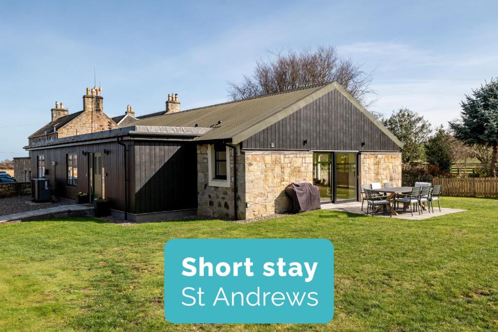 a brick and stone house with the words short stay st andrews at Easter Kincaple Garden Cottage in St. Andrews