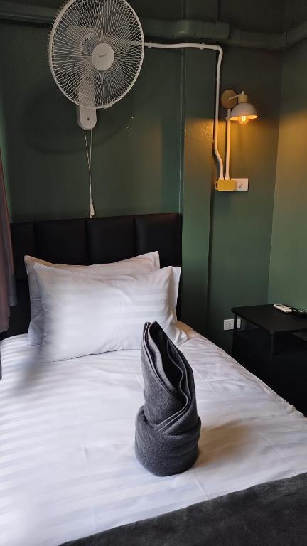 a hat sitting on a bed with a fan at jdreamboxhostelpatong in Patong Beach