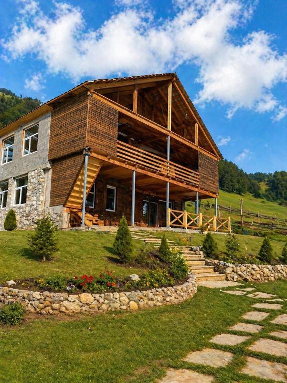 a large wooden house on top of a hill at Guest house River side in Adishi