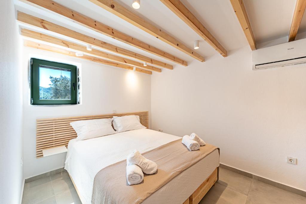 a bedroom with two beds and a tv on the wall at Twin Olive Villas in RhodesRhodes