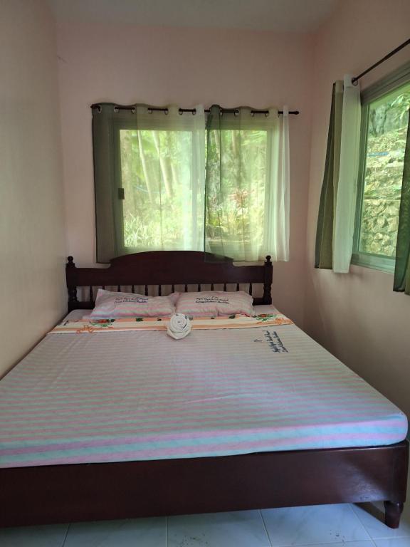 a large bed in a bedroom with a window at Ngak-Ngak Beach Resort in Calatrava