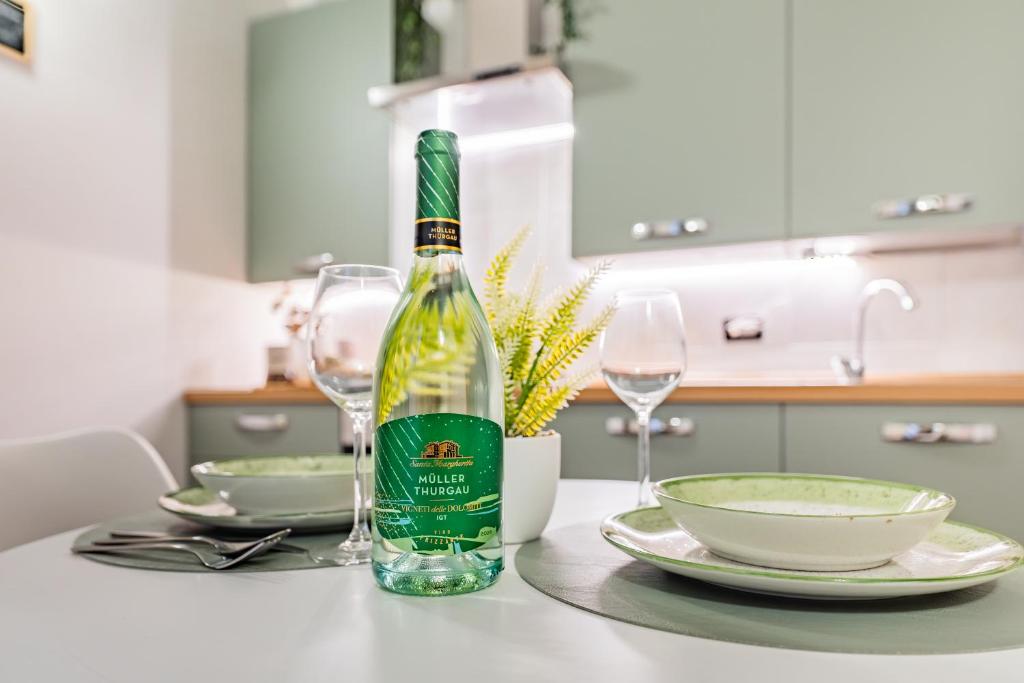 a bottle of wine sitting on a table with glasses at Evergreen House in Cuneo