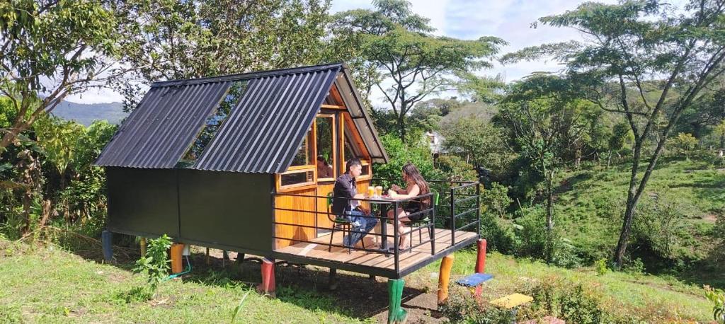 two people sitting at a table in a tiny house at Cabañas tipo glamping in Moniquirá