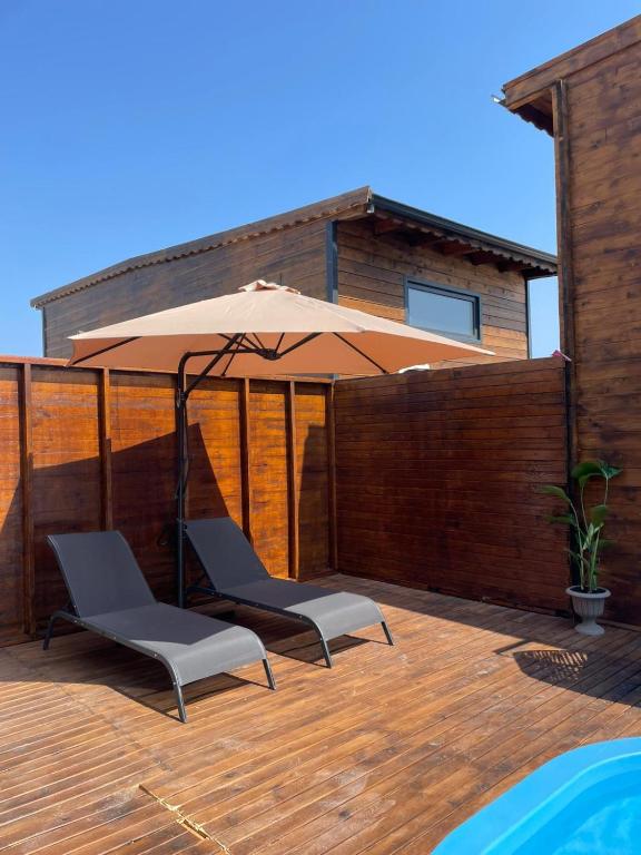 a patio with two chairs and an umbrella at Villa Maris in Demre