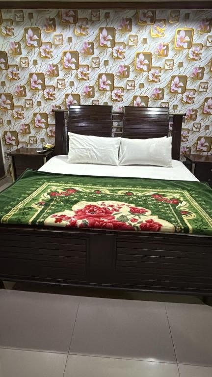 a bedroom with a bed with flowers on it at Hotel Lords Inn in Lahore