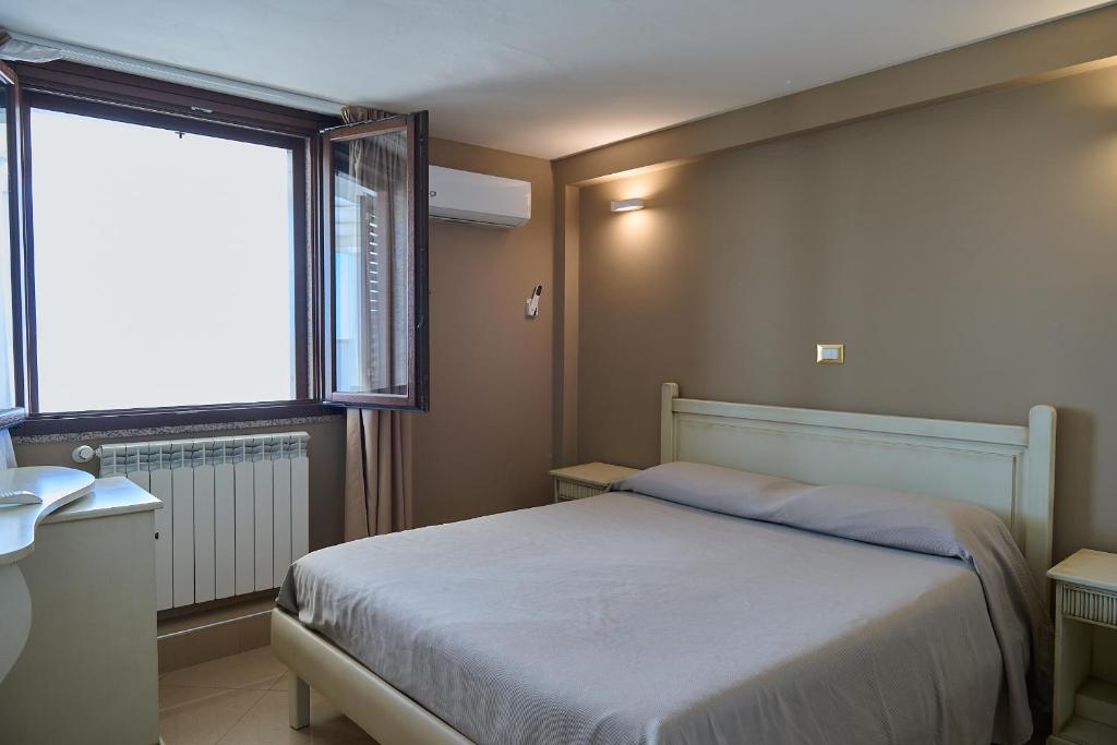 a small bedroom with a bed and a window at Quilungomare in Porto Cesareo