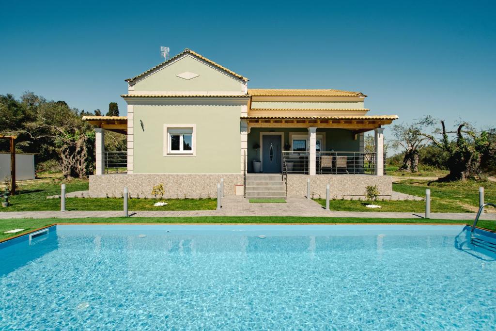 a villa with a swimming pool in front of a house at Luxury Villa Kokos-Private Pool in a Serene Natural Private Estate in Vitalades