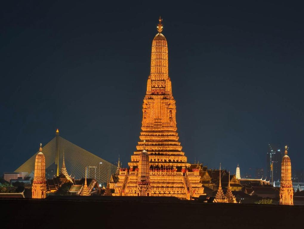 a large white building with a tower at night at TUAN Hotel Bangkok near Wat Arun in Bangkok Yai