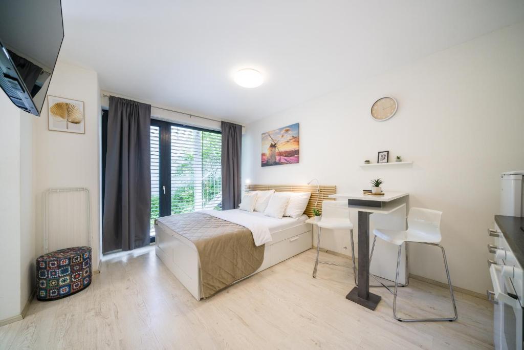 a bedroom with a bed and a desk and a window at Apartia Urban Station in Brno