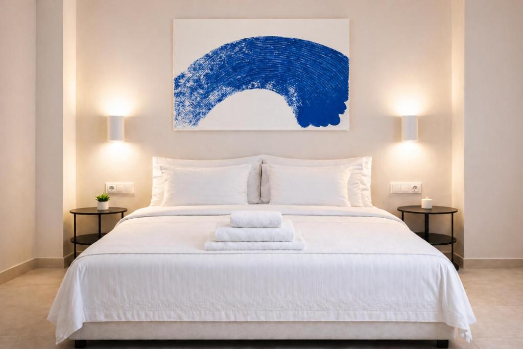 a bedroom with a white bed with a blue painting on the wall at Roca Collection MSuites in Valencia