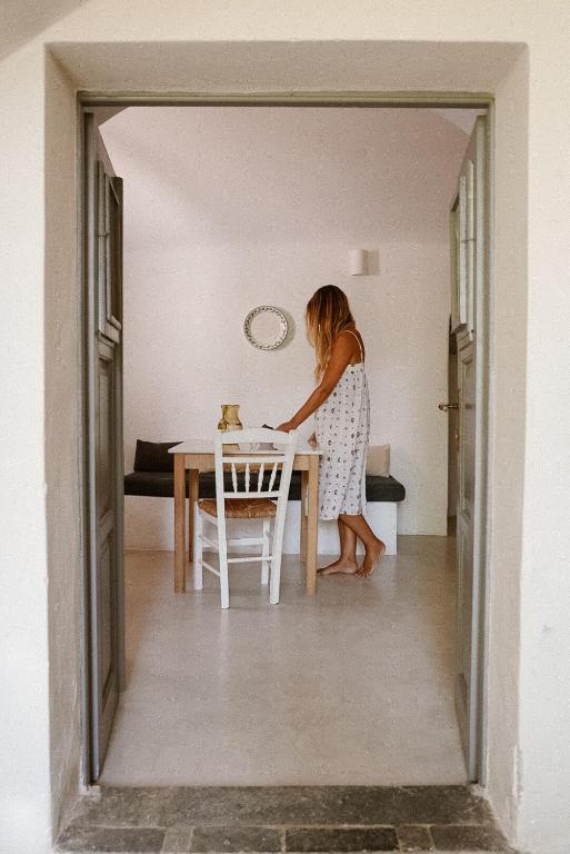 a woman standing at a table in a room at Vasiliki guesthouse in Aroniadika