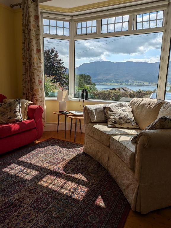 a living room with a couch and a large window at Lough View in Rostrevor