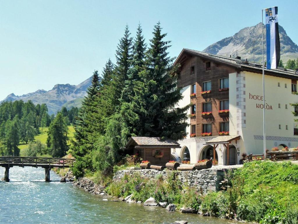 a hotel with a bridge next to a river at Hotel Nolda in St. Moritz