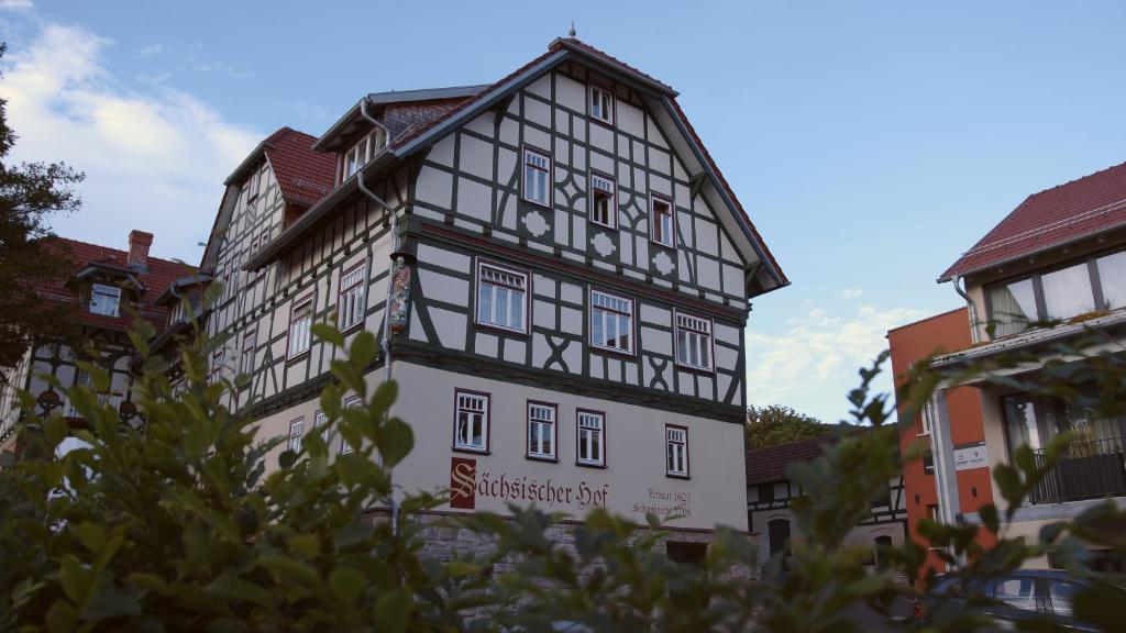 a white and black building with a sign on it at Hotel Saxenhof der Rhöner Botschaft in Dermbach