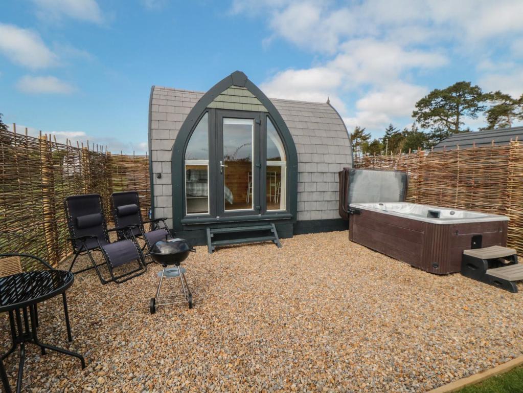 a backyard with a tub and chairs and a fence at Cosy Cocoon in Malton