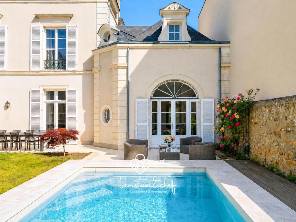 a swimming pool in front of a house at Villa élégante 5 chambres - 24H du Mans - Piscine Chauffée & Garage in Le Mans