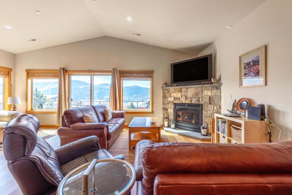 a living room with leather furniture and a fireplace at River Scene 30 Night Minimum in White Salmon