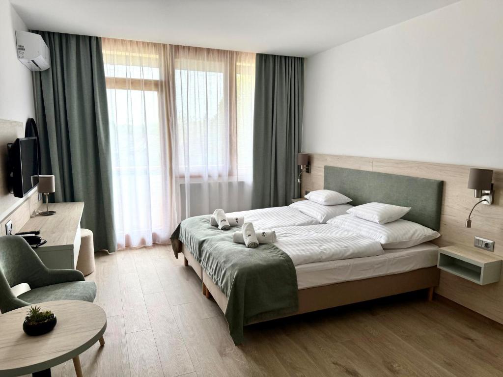 a bedroom with a large bed and a chair at Apartman Hotel in Bük