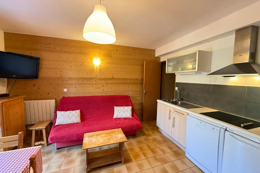 a living room with a red couch in a kitchen at Chalet 8 pers Vars SteMarie Calme in Vars