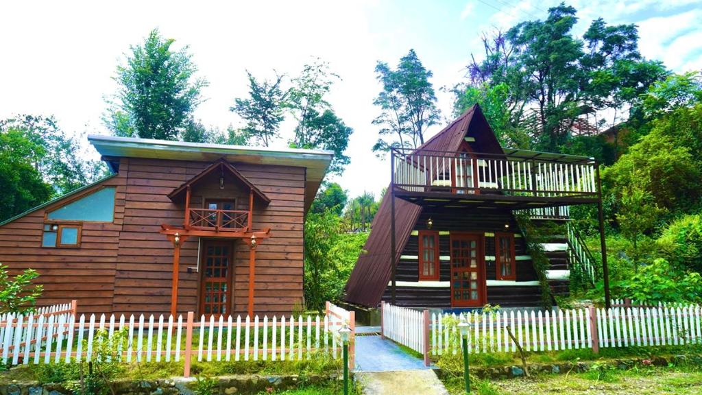 a small wooden house with a balcony and a fence at Hotel YAN Residency Bhimtal - Nainital in Bhīm Tāl