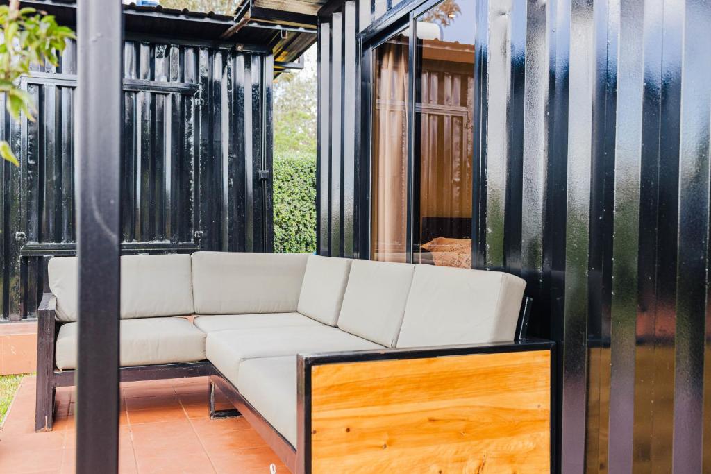 a white couch sitting on top of a porch at Oaklands Tin Nest in Ruiru