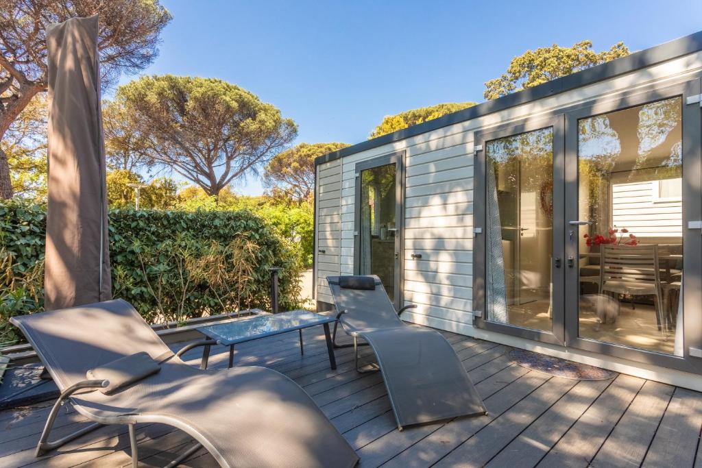 a tiny house with chairs and a bench on a deck at Gassin bungalow in Gassin