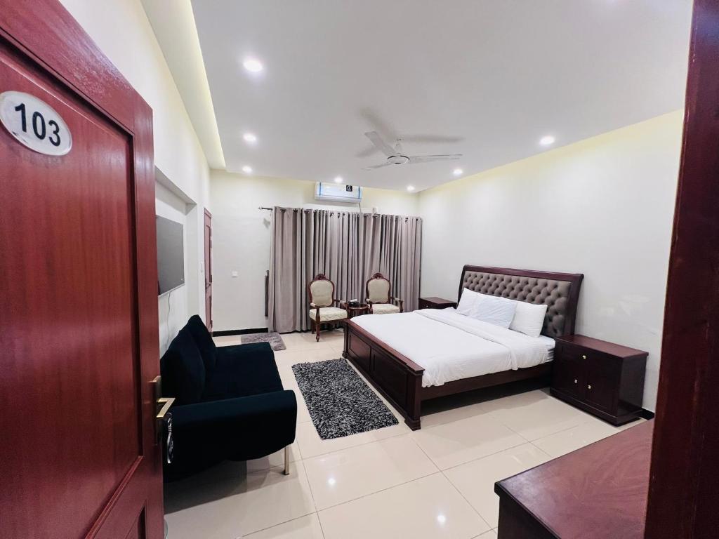 a bedroom with a bed and a chair and a door at Bridge Residency-1 F6 Islamabad in Islamabad