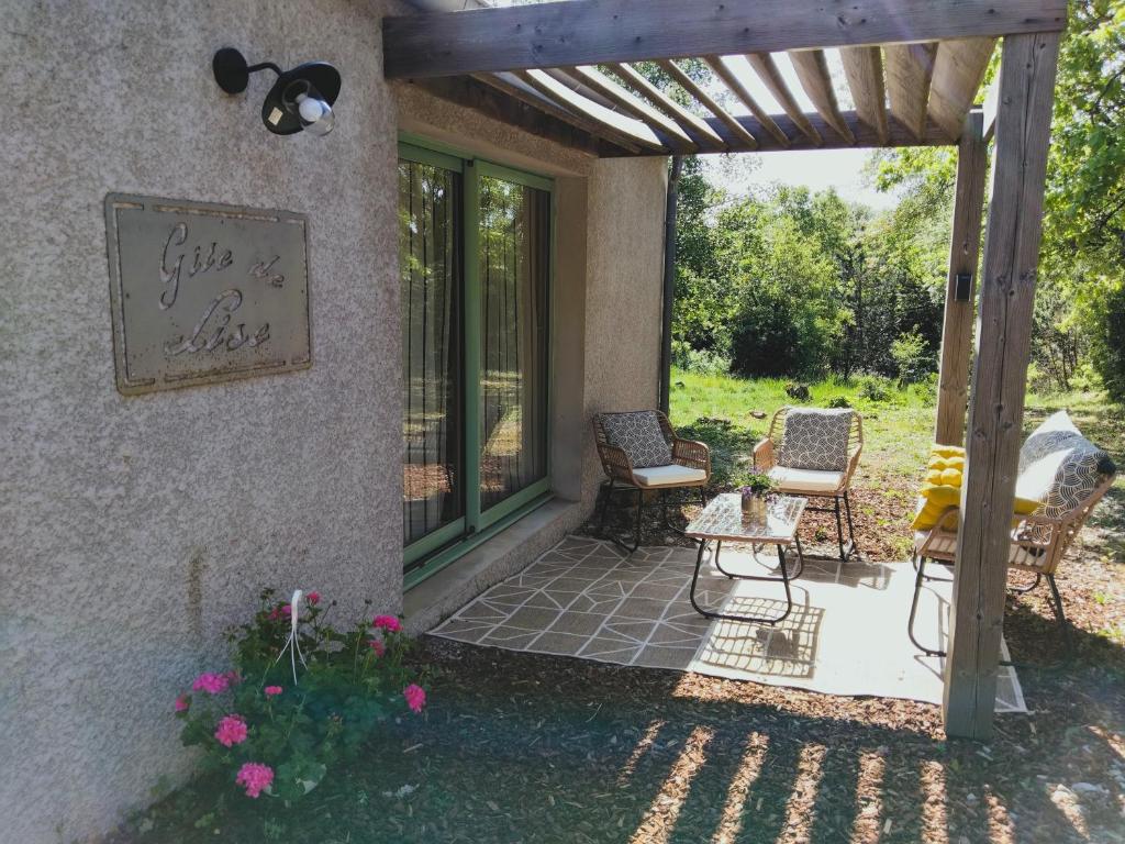 a patio with two chairs and a table and some flowers at Gite de Lise in Blandas