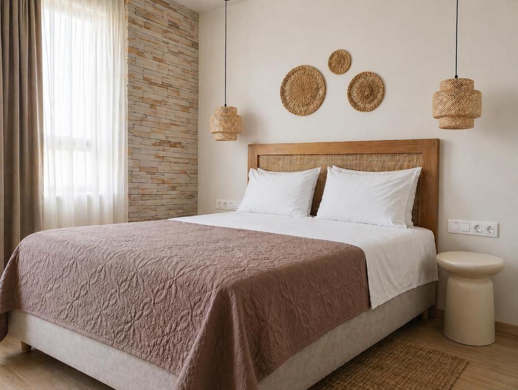 a bedroom with a large bed with white pillows at Lithos in Palaiochora