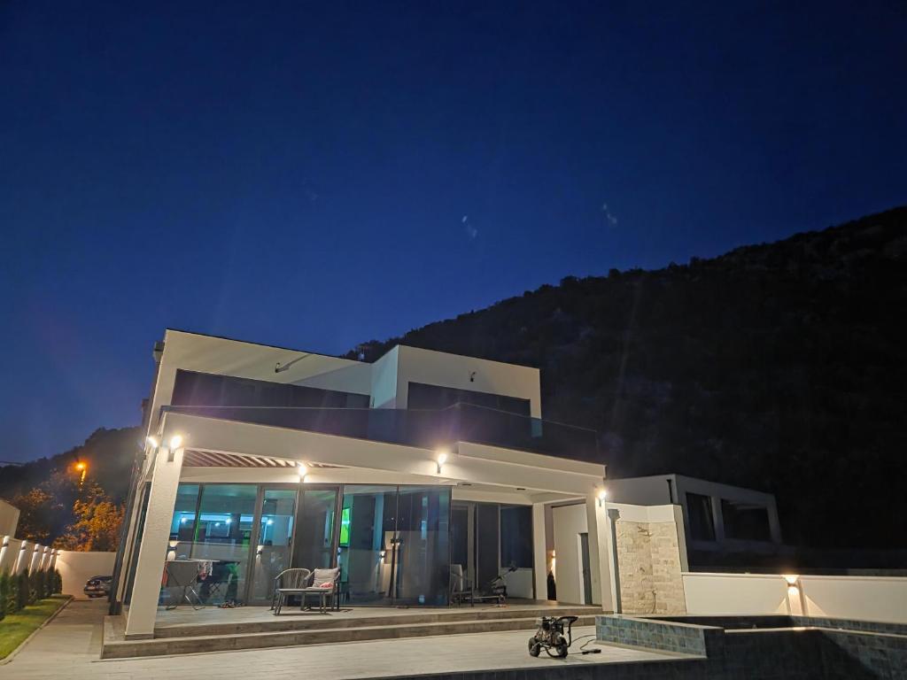 a large white house at night with a patio at The Bunica Residence in Parila