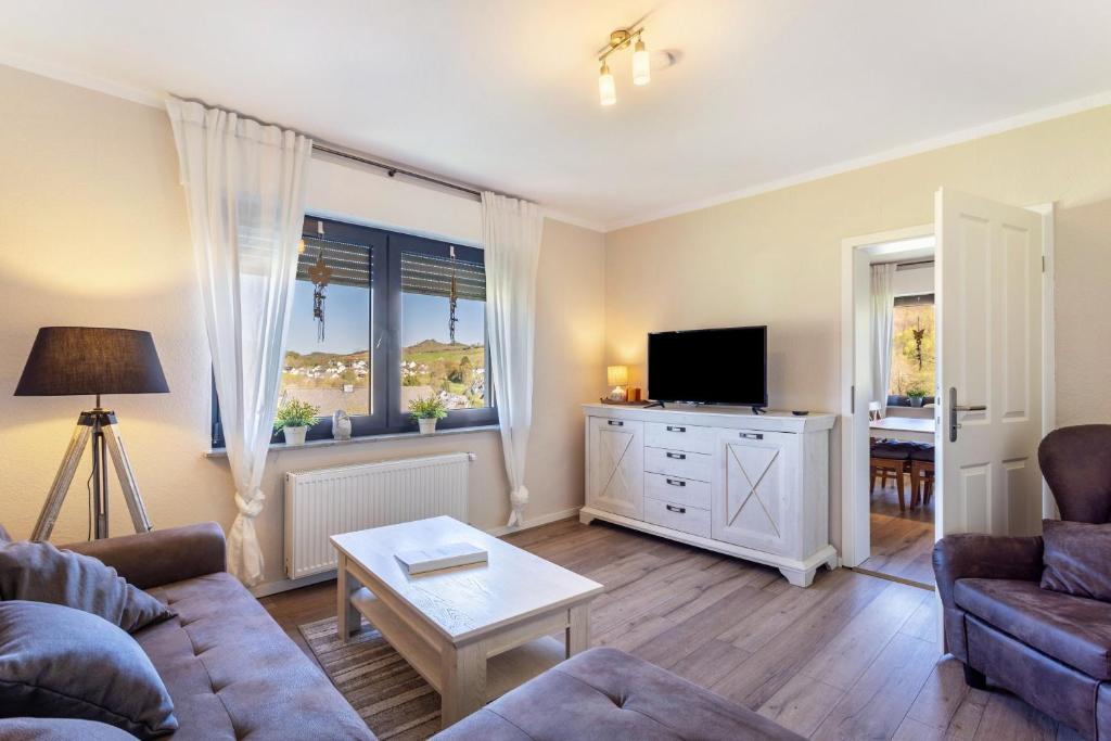 a living room with a couch and a tv at Ferienwohnung Landblick in Brilon