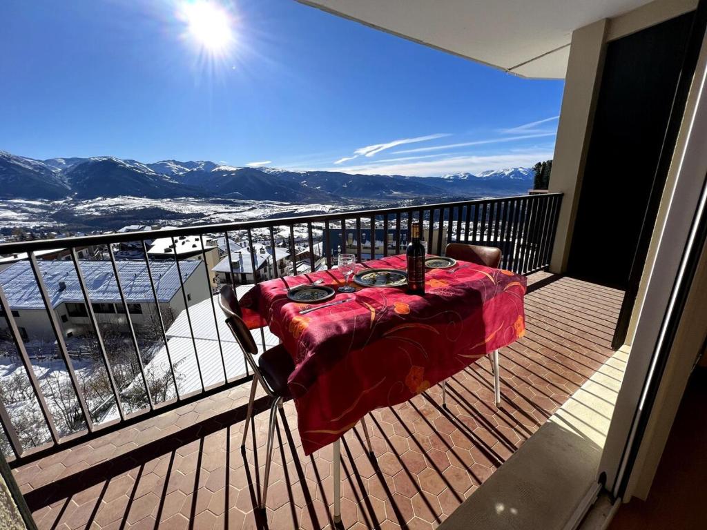 a table on a balcony with a view of the mountains at T3 hypercenter with fireplace, mountain view in Font-Romeu