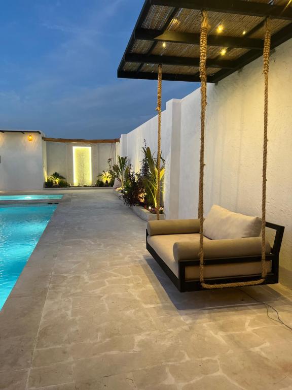 a swinging bed next to a swimming pool at Mykonos Resort in Abu Dhabi