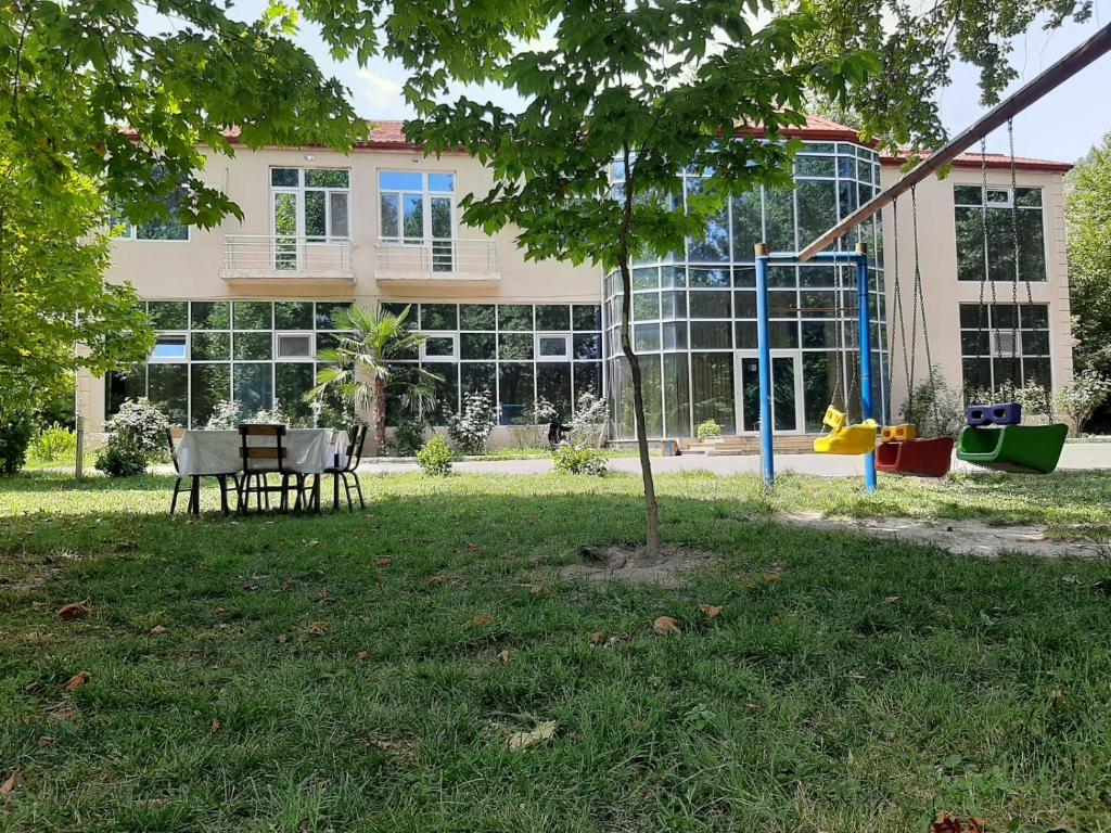 ein Gebäude mit einem Tisch und Stühlen vor einem Gebäude in der Unterkunft ES hotel kolifey in Oğuz