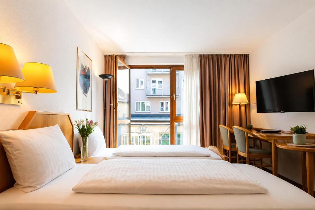 a hotel room with a bed and a desk at CityHotel Feuerbach in Stuttgart