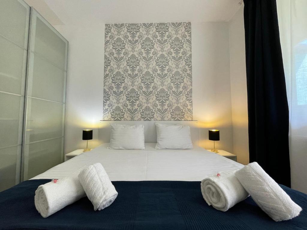 a bedroom with a large bed with two pillows at Corvin Center Suites in Budapest